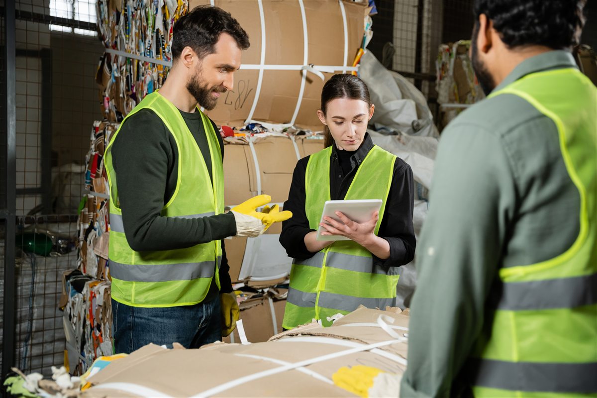 Worker using a tablet in a recycling and waste sorting facility